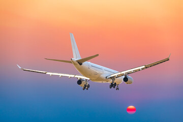 Fototapeta na wymiar Commercial airplane flying above clouds in colorful sunset.Travel,holidays and business concept.