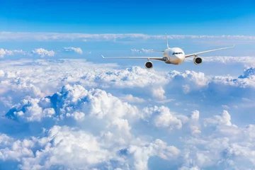 Fototapeten Kommerzielles Flugzeug, das über blauem Himmel und weißen Wolken fliegt. © ABCDstock