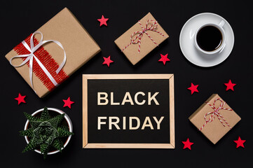 Black Friday sale. Presents, coffee, red stars and blackboard with words in wooden letters on dark background. Shopping for presents concept. Flat lay style, desk top view