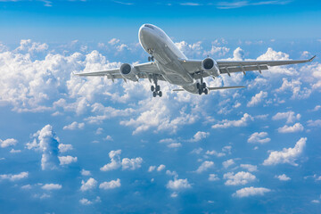 Fototapeta na wymiar Commercial airplane flying above blue sky and white clouds.