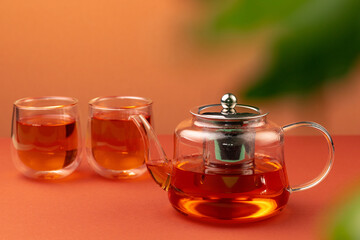 Glass teapot and two glass cups with tea