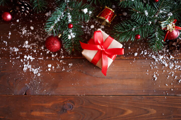 Christmas greeting card concept. Gift box with christmas tree and decoration on wooden background. Copy space, flat lay, top view