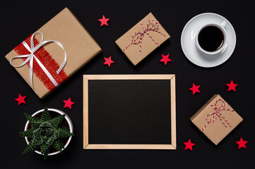 Black Friday sale. Presents, coffee, red stars and blackboard with with copy space for your message on dark background. Shopping and wrapping presents for Christmas. Flat lay style, desk top view