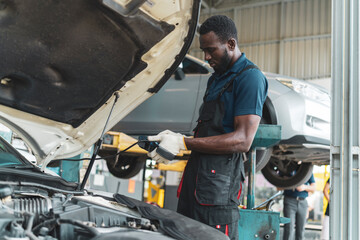 Auto mechanic working in garage, car repair services