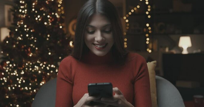 Happy woman using her smartphone on Christmas day