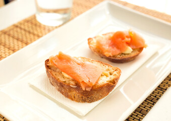 delicious canapes of salted, smoked salmon fillet on slice of fresh ciabatta bread