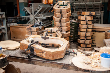 Parts of guitar hanging on the shelves at the factory