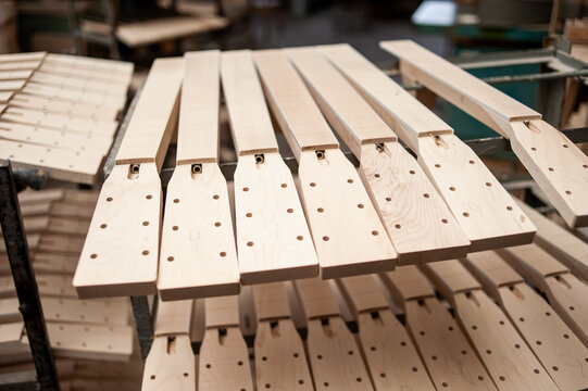 Parts of guitar hanging on the shelves at the factory