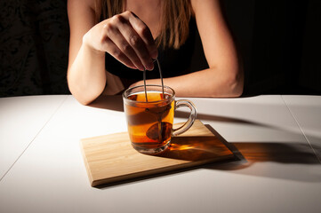a girl at a table and a mug with tea on a bamboo stand