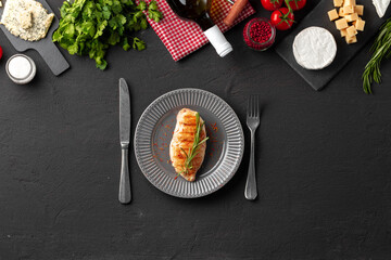 Grilled chicken breast served on black table