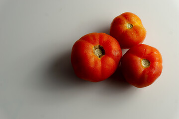 Three red tomatoes on the table