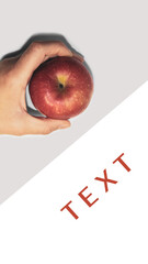 In hand a red apple on a white table. The photo shows a woman's hand holding a ripe red apple.                                                                     