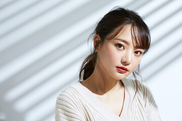 光と影の背景の若い女性のビューティーポートレート