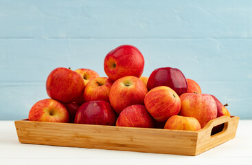 Pile of red apples on wooden tray