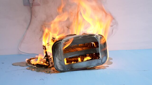 Toaster on fire. Household electrical appliance fire hazard. Overload. Short circuit. Carelessness. Safety in home. Danger home inflammation Insurance concept