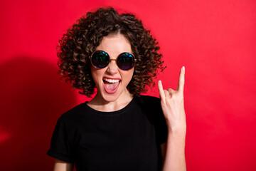 Photo portrait of girl showing rock goat sign isolated on vivid red colored background