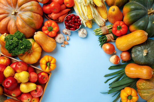 Pumpkins, apples and bell pepper composition on blue background