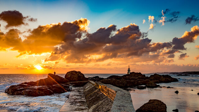 Photographer silhouette. Scenery amazing sunrise at Ahtopol lighthouse, Black Sea, Southeastern Bulgaria. Beautiful clouds and vivid colors in the picture, copy space available. October travel photo.
