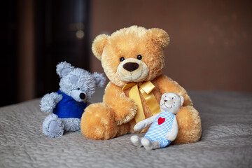 Teddy bears on the bed in the children's room. Baby waiting concept, cute fluffy toys. Horizontal format. Atmospheric mood photo. Front view, overall plan. Soft selective focus