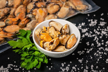 Delicious mussel meat. Seafood with fresh parsley on a dark background.