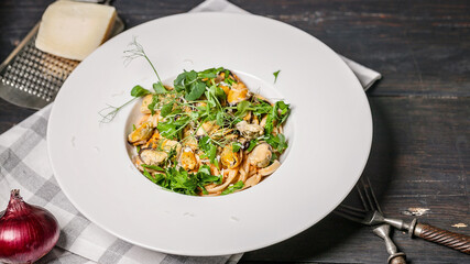 Food still life. Pasta with mussel meat, herbs and cheese. Traditional seafood with fresh parsley on a white plate