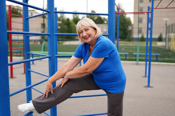 Fototapeta premium beautiful healthy woman 64 years old doing exercises outdoors