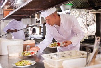 portrait of happy male cook cooking dishes in restaurante