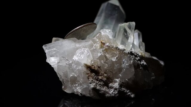 A quartz mineral sample with a dime for size reference. 4k