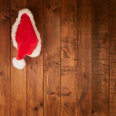 Obraz na płótnie Canvas Santa Claus hat hanging on Wood wall