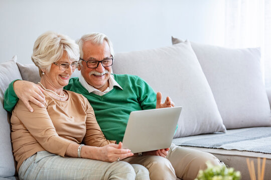 Happy elderly couple having a video call looking involved. Senior couple making video call on laptop at home. Quarantine. Health concept. It's like their loved ones are in their living room