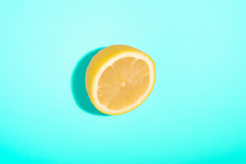Lemon sliced isolated on blue minimal background, tropical citrus fruit