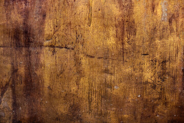 golden metal rough surface with irregular yellow and dark brown tones - worn steampunk background with dirty texture and scratches for an epic wallpaper of a goldmine