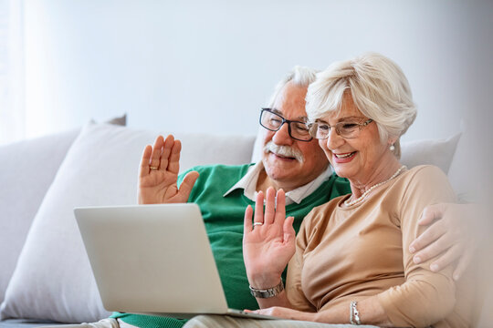 We Love To Video Chat With Our Family. Senior Couple Staying In Touch With Their Family Using Their Laptop At Home. Senior Couple Staying In Touch With Their Family