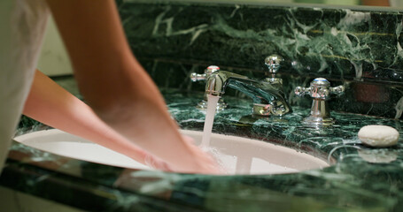 Woman wash hand at toilet