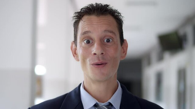 Medium close up shot of business man wearing a suit and tie short hair stylish, so amazed that he say "Wow" happily.