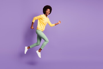 Full size profile side photo of crazy afro american girl jump run empty space isolated on violet color background