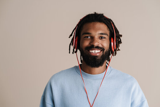Cheerful african american guy in headphones smiling at camera