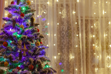 a washed-out Christmas tree and a curtain of garlands on the window, with blurry background, used as a background or texture, soft focus