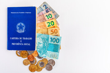 Tradução: República Federativa do Brasil, Ministério do Trabalho. / Carteira de Trabalho e dinheiro do Brasil. Notas e moedas reais. Conceito de salário
