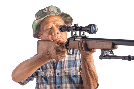 An elderly Asian man holding a sport air rifle with a telescopic and aiming at a telescopic for a target while standing with a white background. Pneumatic gun. Concept of aged people and sport