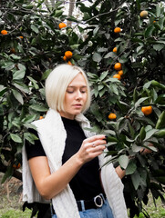 Portrait of a blonde girl in a tangerine garden