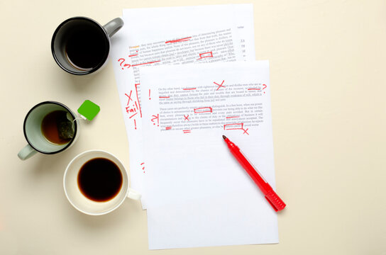 Top view of lot of cups of coffee and paper script, red marks.Concept of checking mistakes in the text
