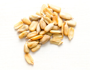 Peeled sunflower seeds on a white table. View from above