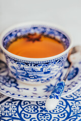 A cup of lemon tea with anise star, white and blue dishes. Copy space