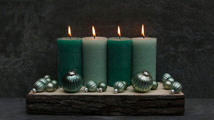 Grüne Kerzen mit Weihnachtskugeln