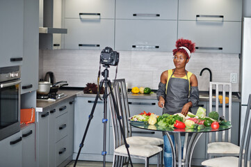 African american woman filming her blog broadcast about healthy food at home kitchen.