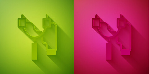 Paper cut Slingshot icon isolated on green and pink background. Paper art style. Vector.