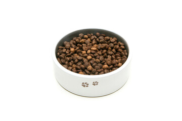 The dog bowl full of the dry pellets isolated in a white background. 