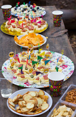 Food and drink on wooden table outdoor, picnic, party time