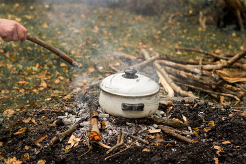 Prepare a food in a pot on campfire outdoor